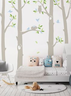 a child's bedroom with white walls and green tree decals on the wall