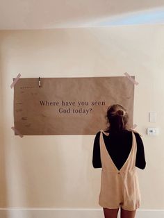 a woman standing in front of a sign that says where have you seen god today?