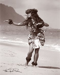 a woman is walking on the beach with her hair blowing in the wind and wearing an elaborate headdress