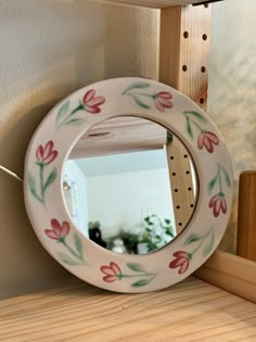 a mirror sitting on top of a wooden shelf