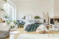 a living room filled with furniture and a fire place next to a large window on top of a hard wood floor