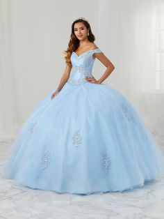 You'll love twirling around in this embellished off the shoulder ball gown with A-line skirt by House of Wu LA Glitter 24086. Fit for a modern princess, this off the shoulder sweetheart neckline ball gown features elegant lace motifs that are also mimicked on the detachable overskirt. Full glitter tulle skirt is decorated with scattered lace motifs. This look is finished with a corset back. House of Wu LA Glitter Designers Collection: Fall 2021 Style Number: 24086 Fabric: Mikado/Tulle/Glitter Tu Blue And Silver Quinceanera Dresses, Blue And Silver Quinceanera, Silver Quinceanera Dresses, Sleeve Bridal Gown, Quinceañera Dresses, Lace Motifs, Long Sleeve Bridal Gown, Debutante Ball, Big Dresses