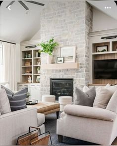 a living room filled with furniture and a flat screen tv mounted on a wall above a fireplace