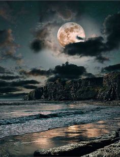 an image of a full moon in the sky above some water and land with rocks