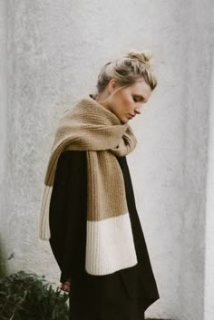 a woman is standing outside wearing a scarf