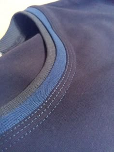 a close up view of the side of a blue shirt with stitching on it