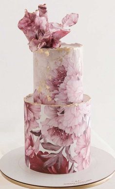 a three tiered cake with pink flowers on it