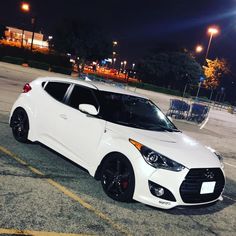 a white car parked in a parking lot at night