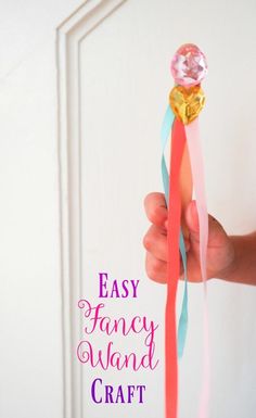 a hand holding a candy wand with the words easy fancy wand craft written on it