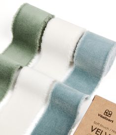 two rolls of blue and white ribbon on top of each other next to a tag