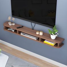 a flat screen tv sitting on top of a wooden shelf next to a wall mounted television