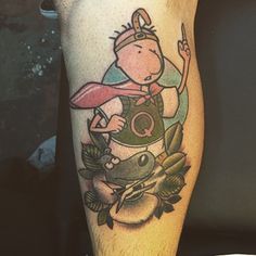 a man's leg with a cartoon character on it and an animal in the background