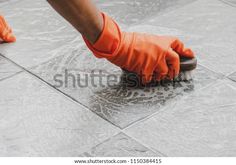 a person in orange gloves is cleaning the floor