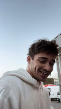 a man in a white hoodie is smiling