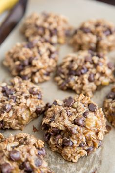 chocolate chip oatmeal cookies are on a baking sheet with a banana in the background