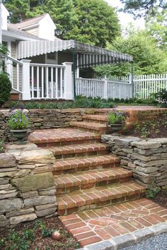 stone steps lead up to a white picket fence