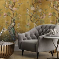 a chair and table in front of a wallpapered room with flowers on it