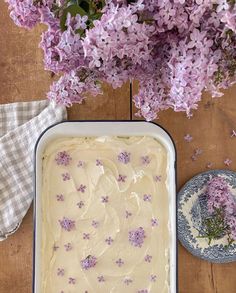 a cake with white frosting and purple flowers