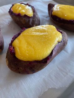 four baked potatoes with yellow sauce on them