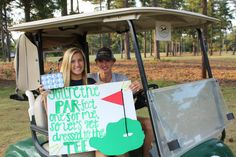 two people sitting in a golf cart holding signs