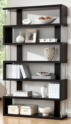 a book shelf with books and a vase on top