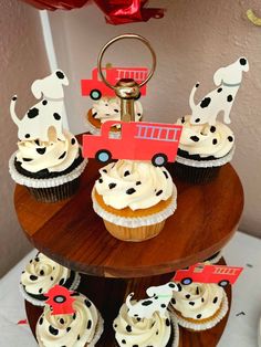 cupcakes with white frosting and black spots on them are arranged in the shape of a firetruck