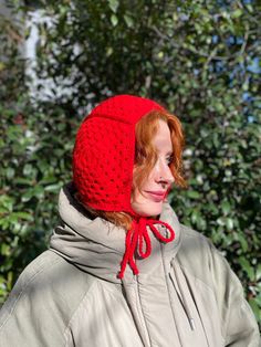 a woman wearing a red knitted hat and scarf