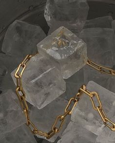 a gold chain is on top of ice cubes in a bucket full of ice