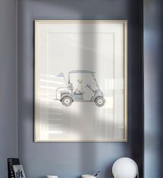 a golf cart is framed on the wall above a table with cups and utensils