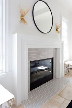 a living room with a fireplace and mirror on the wall