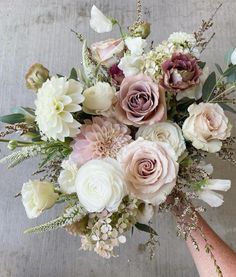 a bouquet of flowers is being held by someone's hand in front of the camera