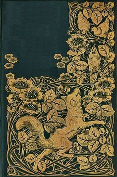 an old book with gold trimmings and flowers on the cover, depicting a fox surrounded by leaves