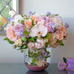 a vase filled with lots of pink and purple flowers