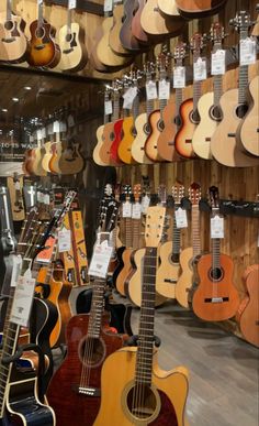 many guitars are on display in a store