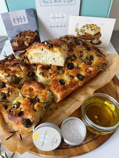 bread with olives and other toppings on a wooden platter next to some cards