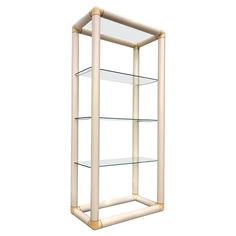 a glass shelf with three shelves on each side and gold trimmings around the bottom