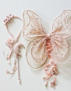 two hair accessories are laying next to each other on a white surface, one is pink and the other is gold