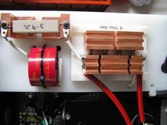 an electronic device with three batteries attached to it and two red wires connected to each other