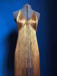 a mannequin wearing a gold dress with fringes