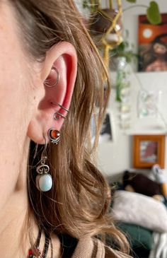 a close up of a person wearing some kind of earring with two different colored beads