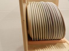 a stack of white plates sitting on top of a wooden shelf