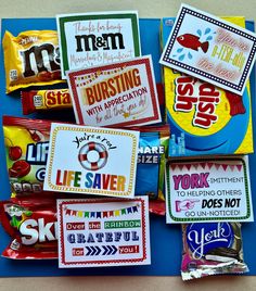 candy wrappers are laid out on top of a blue board with stickers in them