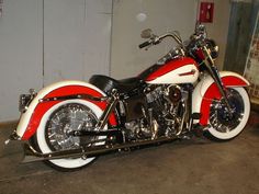 a red and white motorcycle parked in a garage