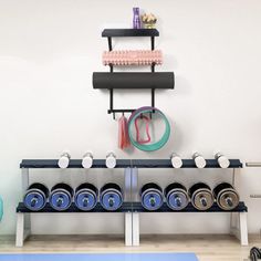 there is a rack with many different items on it in the room, including dumbs and exercise mats