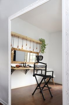 a chair sitting on top of a hard wood floor next to a mirror in a room