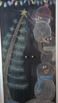 a chalk drawing of a christmas tree and snowmen on a blackboard door with lights