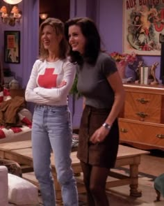 two women standing next to each other in a living room