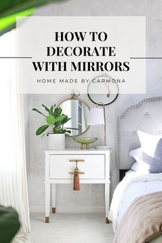 a bedroom with white furniture and green plants on the nightstand, in front of a mirror