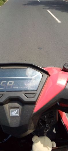 the front view of a red motorcycle driving down a road