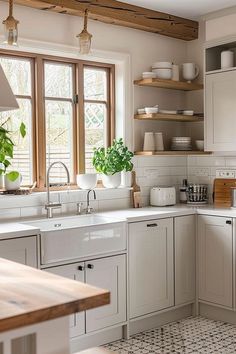 a kitchen filled with lots of white cabinets and counter top space next to a window